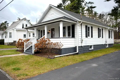 a front view of a house with a yard porch and wooden fence