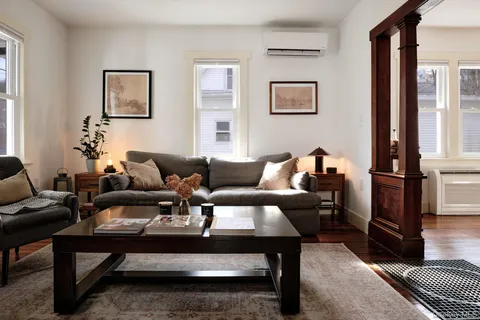 a living room with furniture a rug and a window