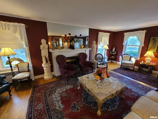 a living room with furniture fireplace and a large window