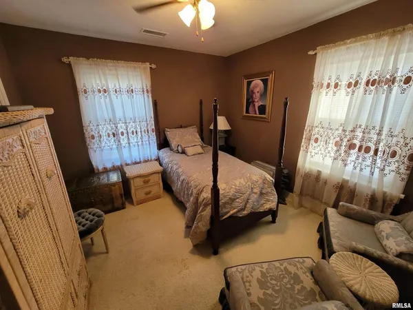 a bedroom with a bed a lamp and a chandelier