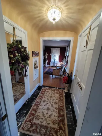 a view of a hallway to a livingroom with furniture