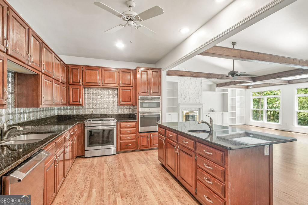 230 Haynes Road Moreland, GA 30259 - Photo 8 of 38 a kitchen with stainless steel appliances granite countertop a sink stove and cabinets
