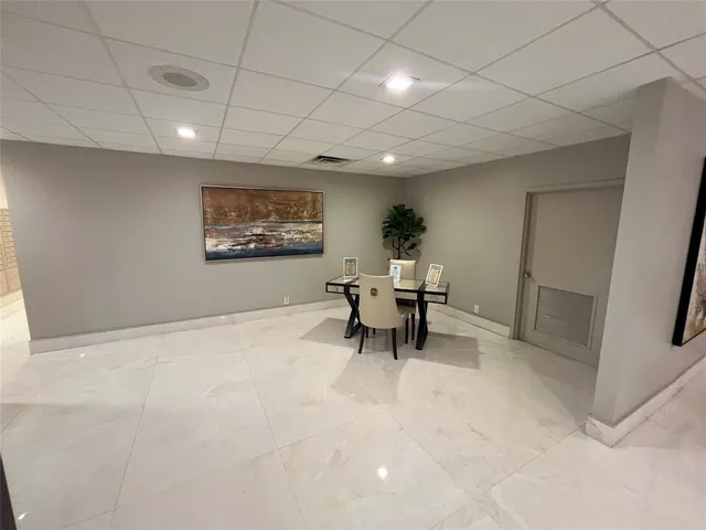 a view of a lobby with black floor and potted plants