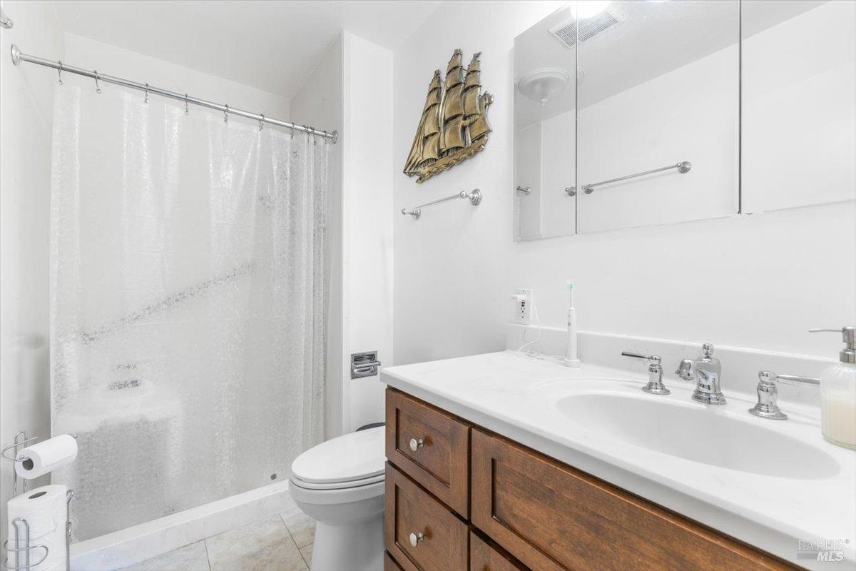 442 Las Casitas Court, Unit A Santa Rosa, CA 95403 - Photo 16 of 33 a bathroom with a granite countertop sink a toilet and a mirror