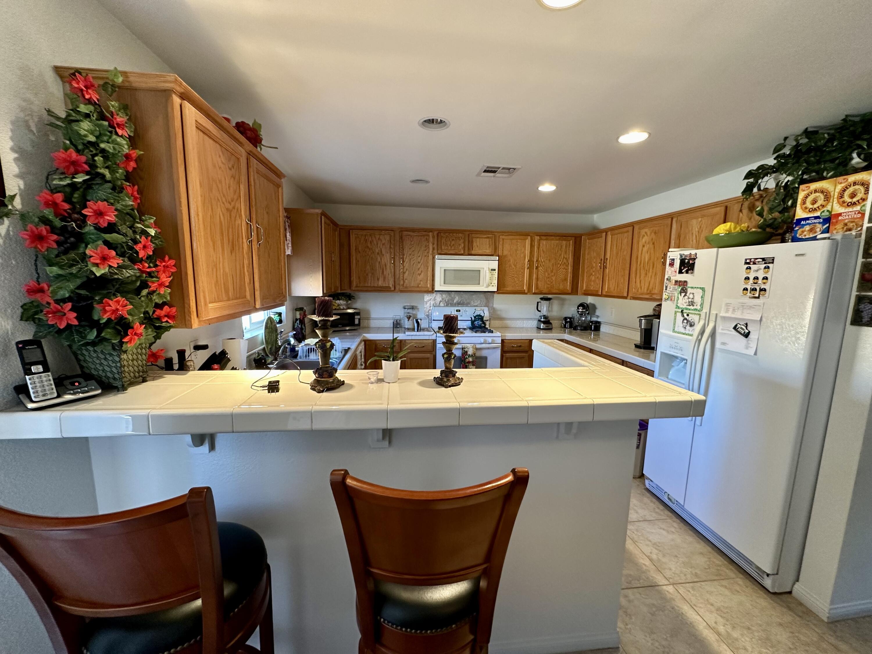 575 West Rice Street Blythe, CA 92225 - Photo 4 of 24 a kitchen with stainless steel appliances granite countertop a dining table chairs refrigerator and sink