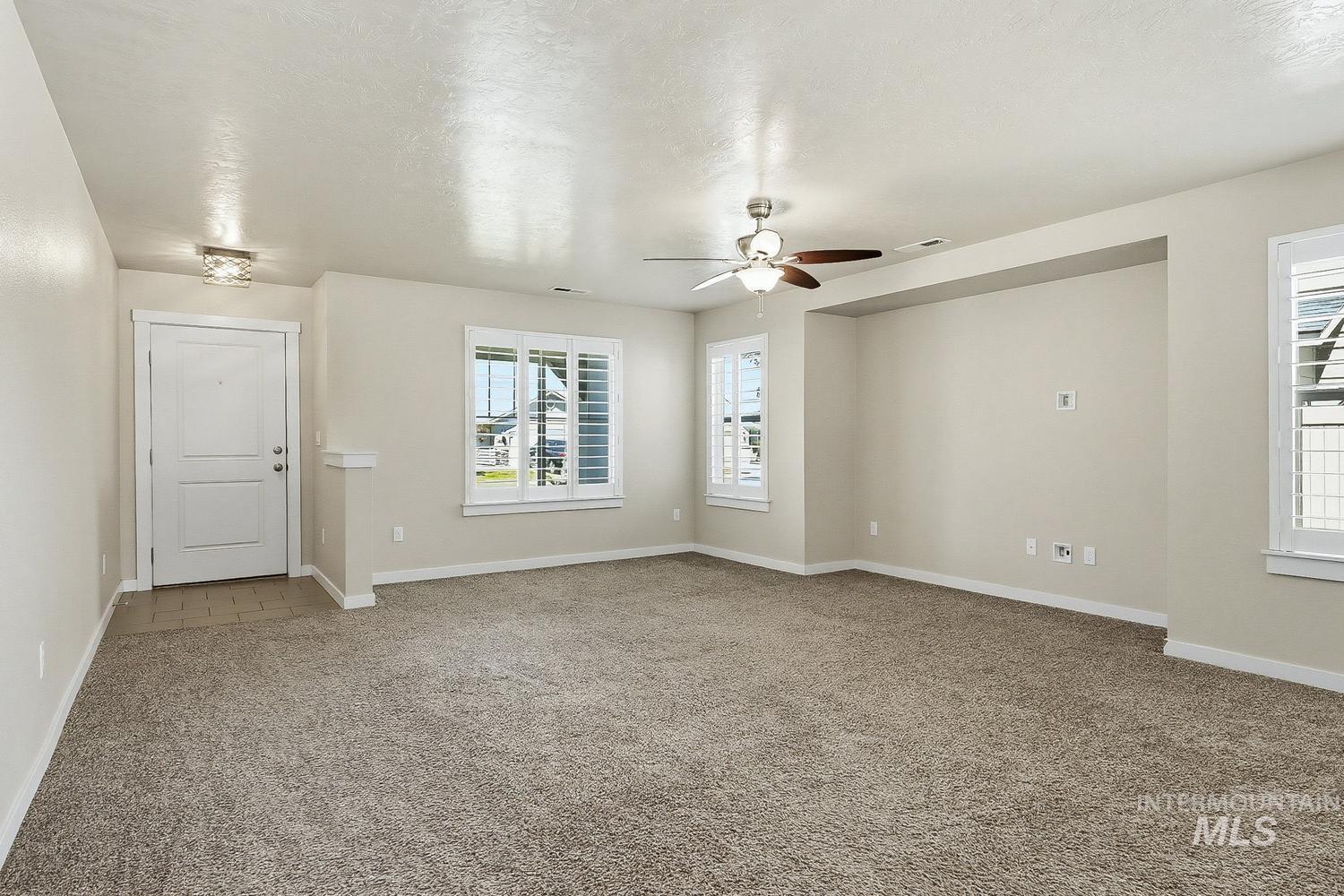 846 North Hidden View Way Star, ID 83669 - Photo 4 of 49 Spacious interior room featuring plush carpeting, a ceiling fan with integrated lighting, and multiple windows with white plantation shutters
