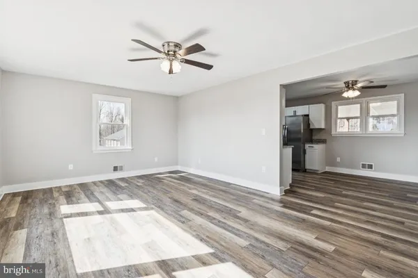 a view of empty room with wooden floor and window