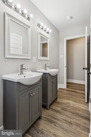 a spacious bathroom with a double vanity sink a mirror and a