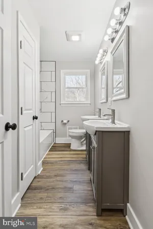 a spacious bathroom with a double vanity sink a mirror and a shower