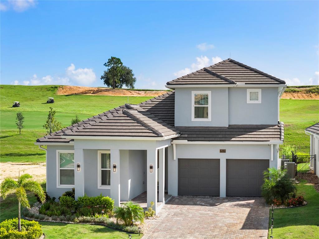 a front view of a house with a yard and potted plants