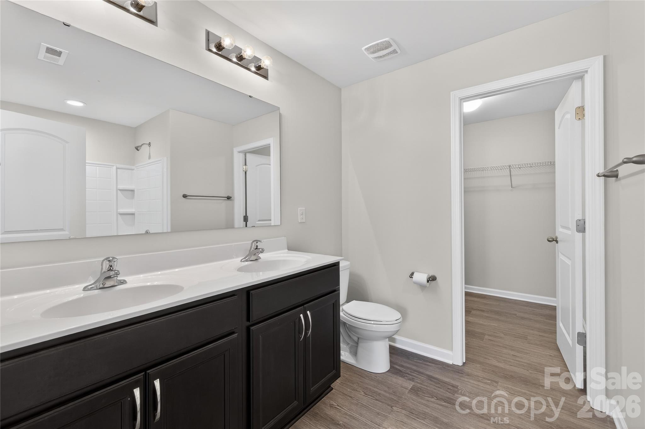128 Pleasant Hill Street Lancaster, SC 29720 - Photo 17 of 26 a bathroom with a double vanity sink a toilet and a mirror