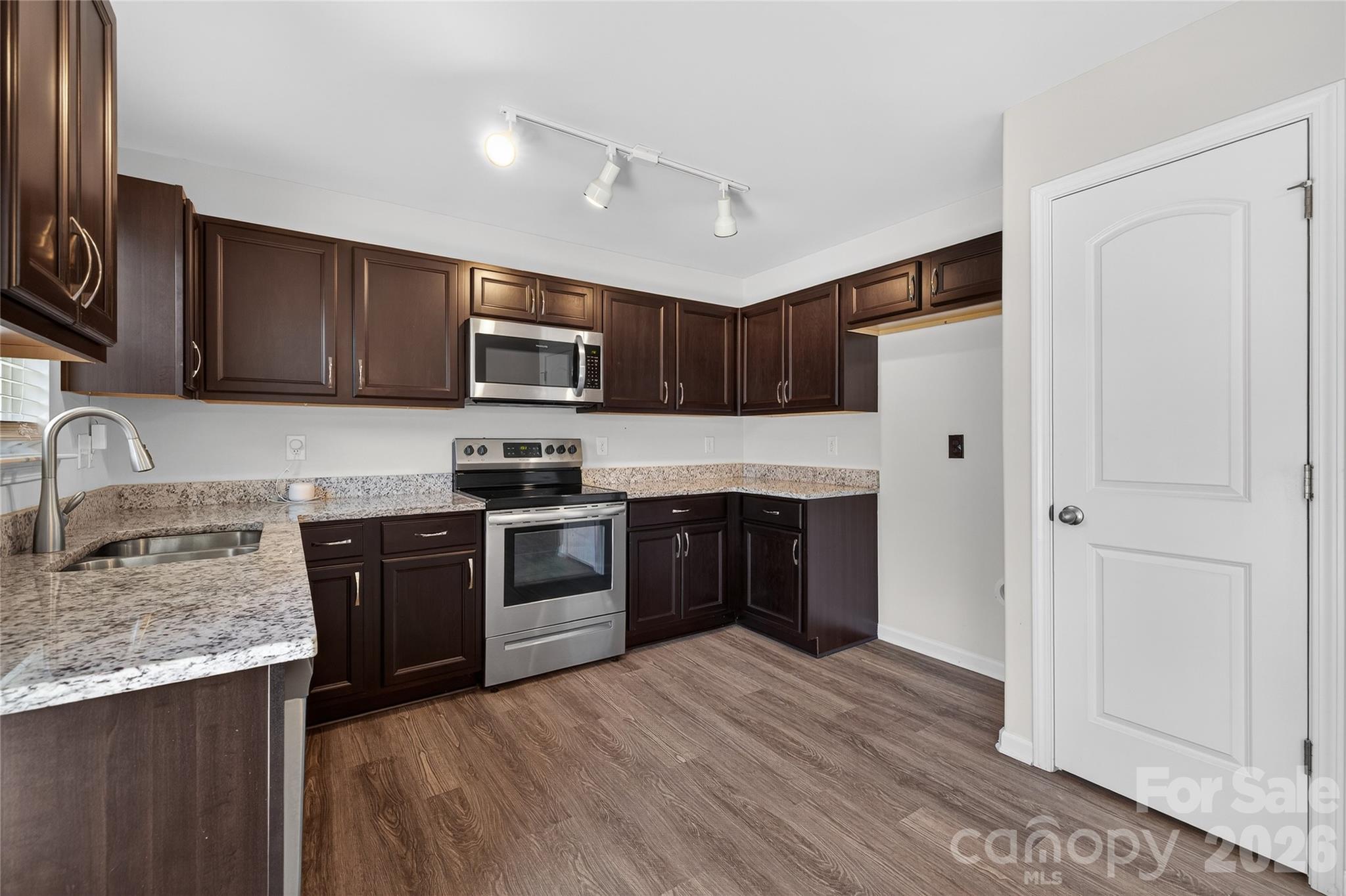 128 Pleasant Hill Street Lancaster, SC 29720 - Photo 5 of 26 a kitchen with granite countertop wooden cabinets and stainless steel appliances