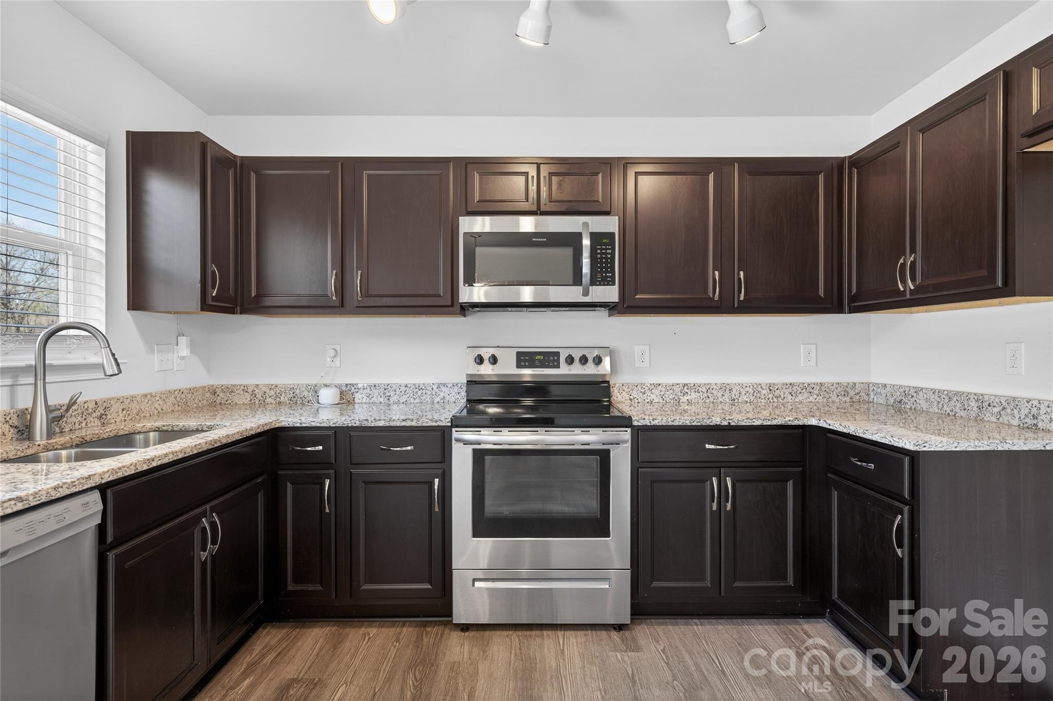 128 Pleasant Hill Street Lancaster, SC 29720 - Photo 6 of 26 a kitchen with granite countertop a stove top oven microwave and cabinets