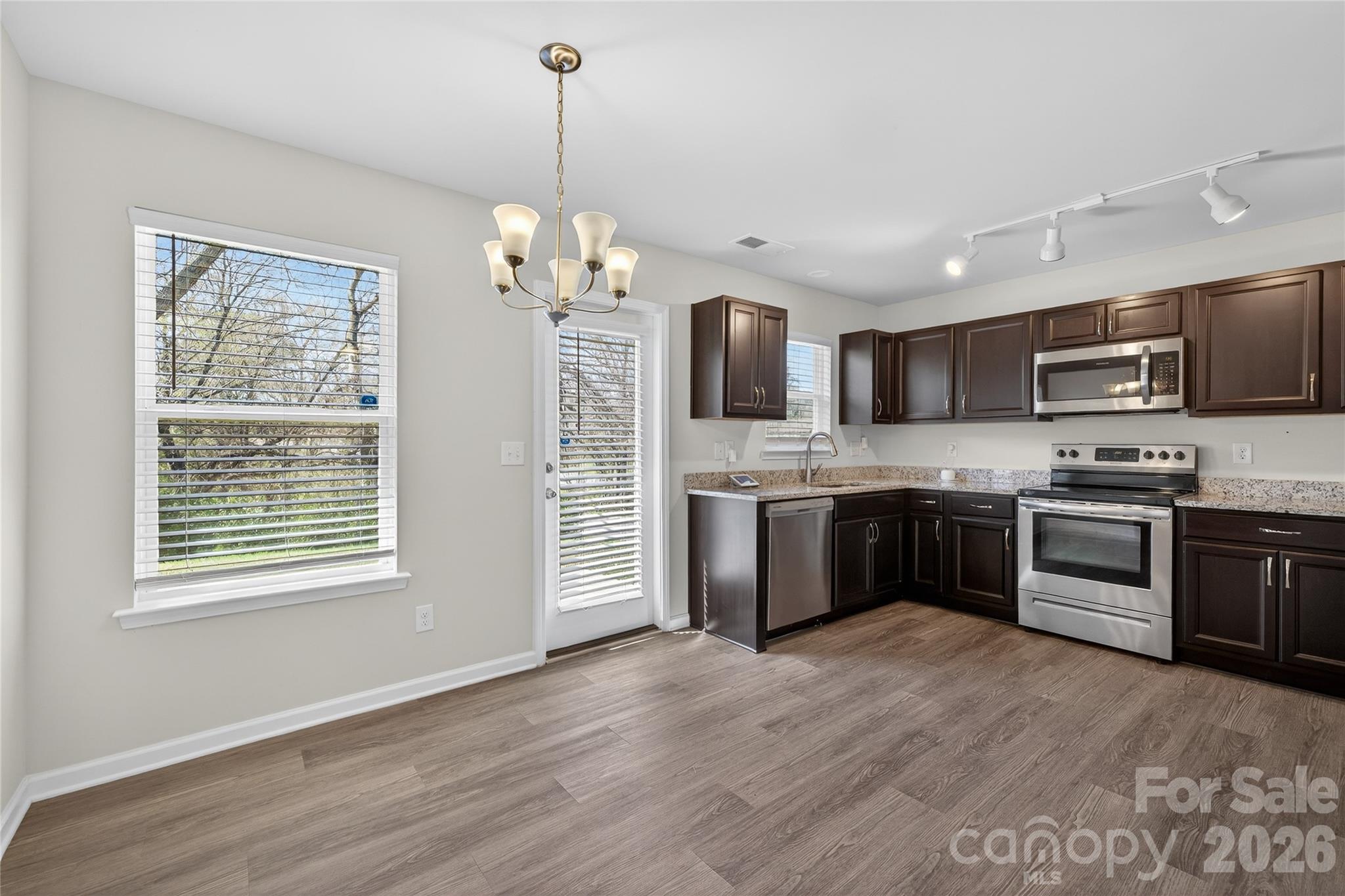 128 Pleasant Hill Street Lancaster, SC 29720 - Photo 7 of 26 a open kitchen with stainless steel appliances granite countertop a stove top oven a sink dishwasher a refrigerator and a fireplace with wooden floor
