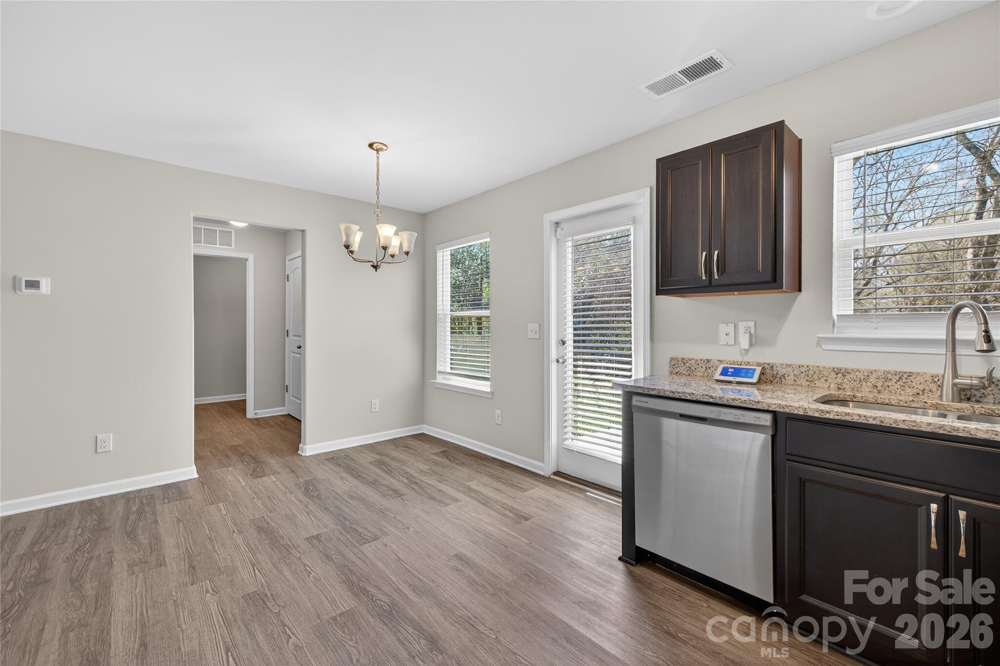 128 Pleasant Hill Street Lancaster, SC 29720 - Photo 8 of 26 a kitchen with granite countertop a sink cabinets and wooden floor