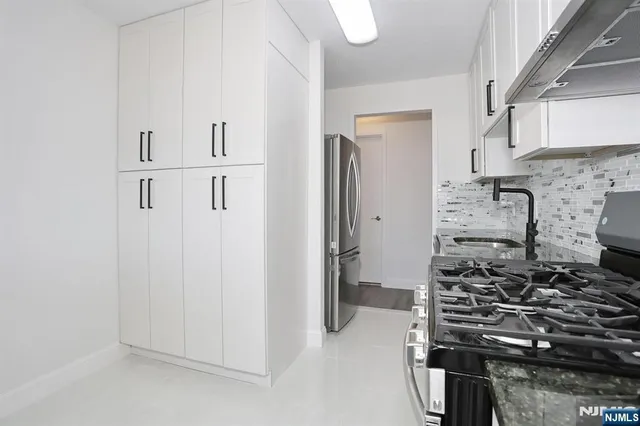 a kitchen with stainless steel appliances a sink stove and cabinets