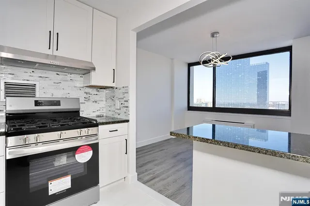 a kitchen with granite countertop white cabinets and white appliances