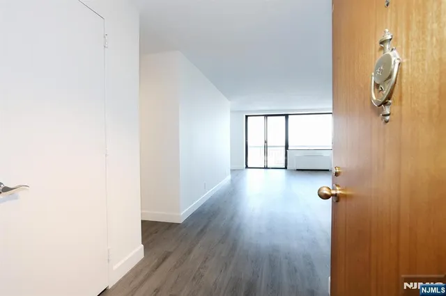 an empty room with wooden floor and a ceiling fan