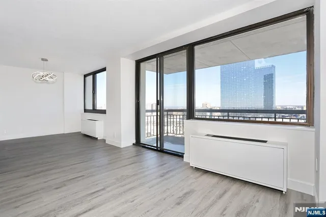 a view of a hallway with wooden floor and a kitchen