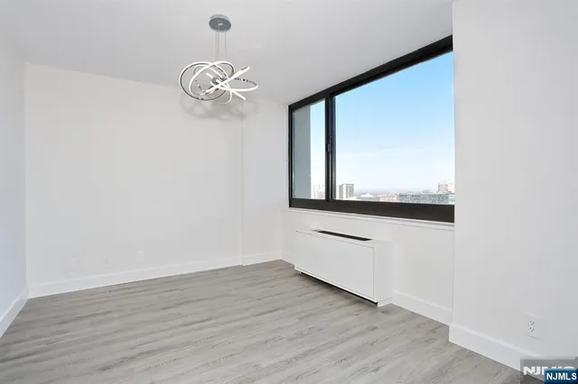 a room with wooden floor and windows