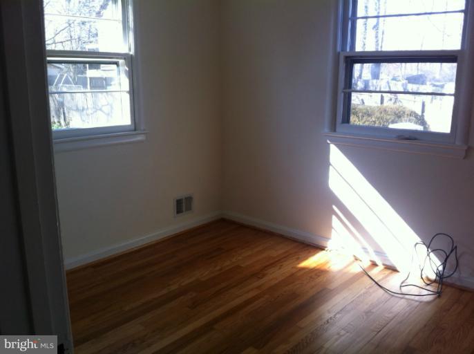 3914 Isbell Street Silver Spring, MD 20906 - Photo 3 of 17 an empty room with wooden floor and windows