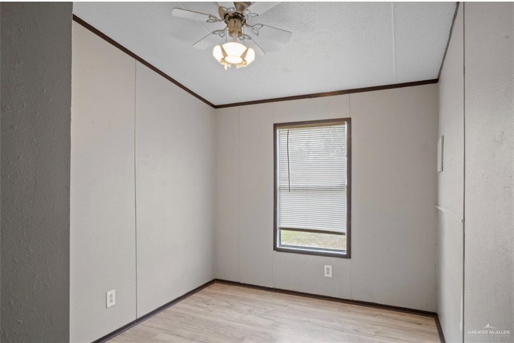 115 East Which Way Pharr, TX 78577 - Photo 15 of 20 Spare room featuring crown molding, light wood-style floors, and ceiling fan