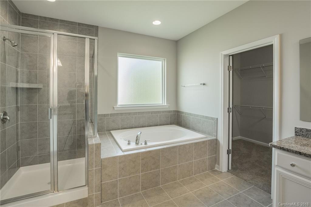 5116 Waterloo Drive, Unit 60 Tega Cay, SC 29708 - Photo 22 of 36 a bathroom with a bathtub and a shower
