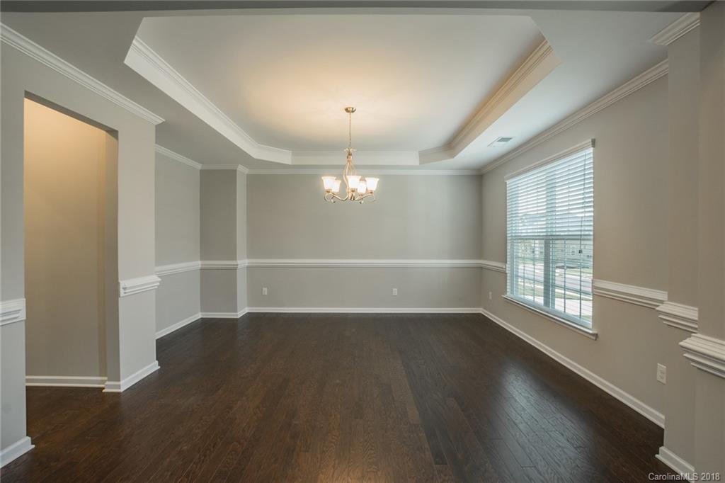 5116 Waterloo Drive, Unit 60 Tega Cay, SC 29708 - Photo 7 of 36 an empty room with wooden floor and windows
