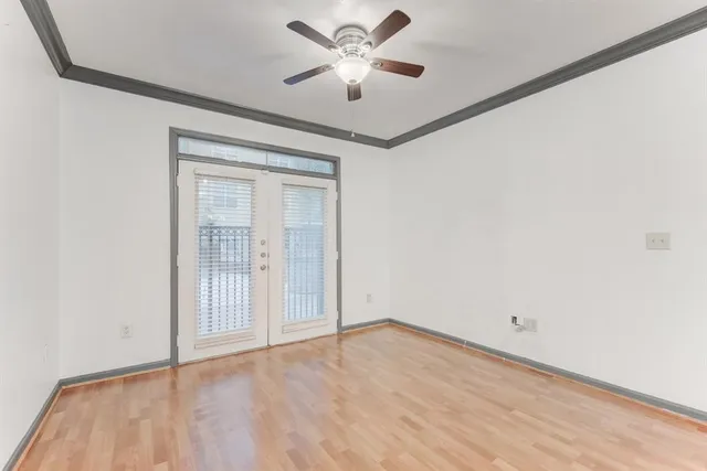 an empty room with a window and a ceiling fan