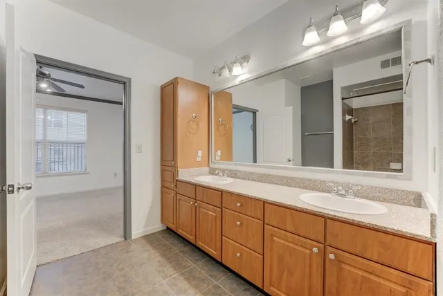 a spacious bathroom with double sink and a mirror