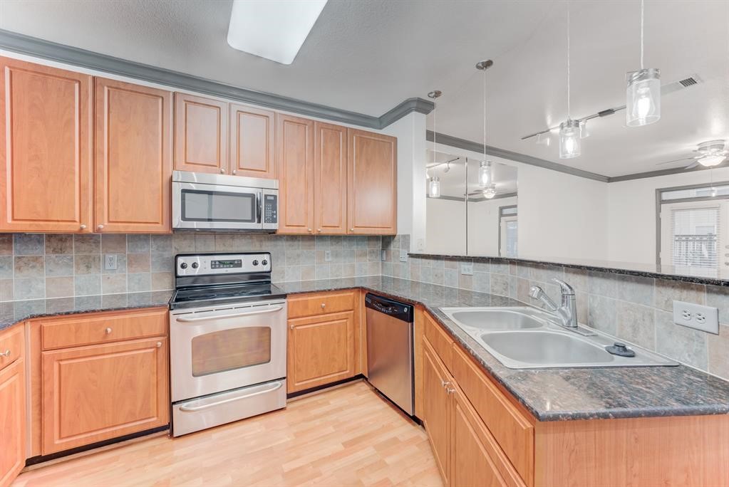 1711 Old Spanish Trail, Unit 110 Houston, TX 77054 - Photo 6 of 31 a kitchen with stainless steel appliances granite countertop a sink stove and microwave