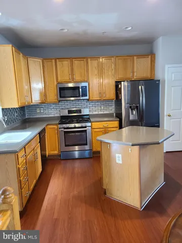 a kitchen with wooden cabinets and refrigerator
