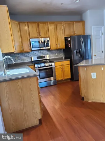 a kitchen with kitchen island a sink a stove and a microwave