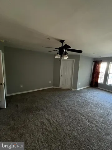 a view of a livingroom with a ceiling fan and window