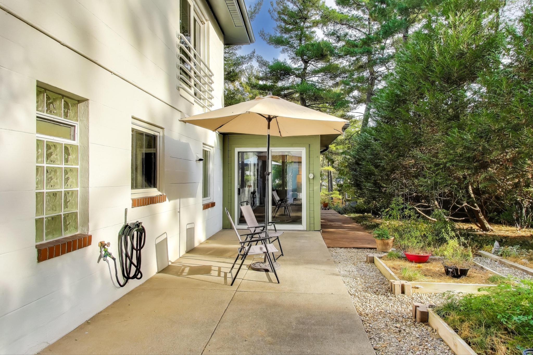 49 Aspen Road Ogden Dunes, IN 46368 - Photo 38 of 42 a view of a patio with table and chairs potted plants with wooden floor and fence