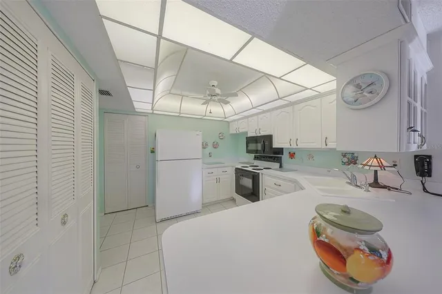 a kitchen with granite countertop a sink a stove and cabinets