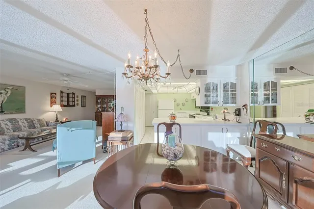 a dining room with furniture a chandelier and wooden floor
