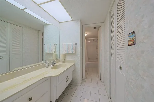 a spacious bathroom with a double vanity sink a mirror and a shower