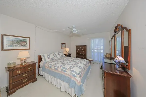 a spacious bedroom with a bed and a dresser