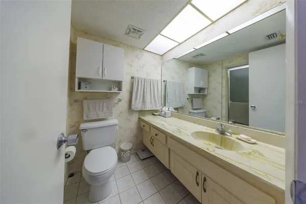 a bathroom with a granite countertop sink mirror vanity and toilet
