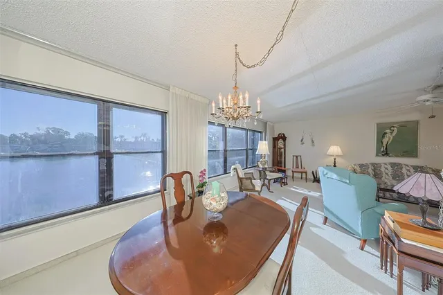 a dining room with furniture a large window and a chandelier