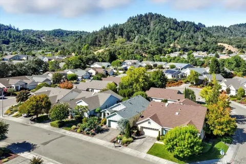 an aerial view of a city with lots of residential buildings and mountain view in back