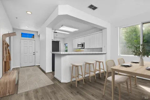 a kitchen with a table chairs refrigerator and cabinets
