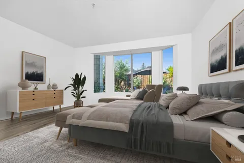 a bedroom with a large bed and a flat tv screen on dresser