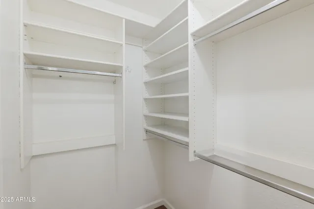 a view of walk in closet with empty racks