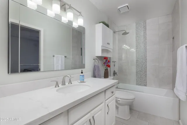 a bathroom with a sink toilet vanity and shower