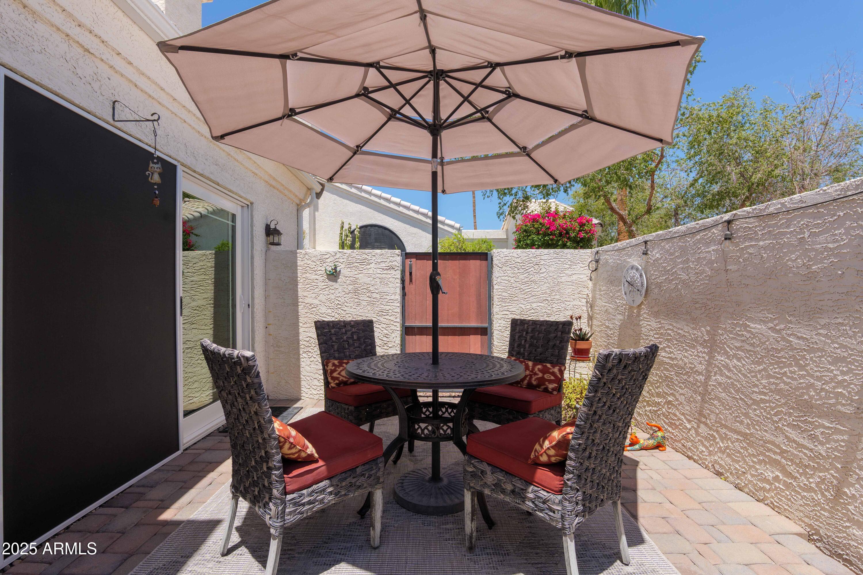 2100 West Lemon Tree Place, Unit 78 Chandler, AZ 85224 - Photo 22 of 32 a view of a dining table and chairs under an umbrella