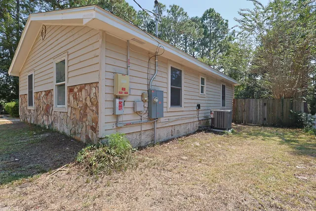 an empty room with wooden floor and windows with curtains