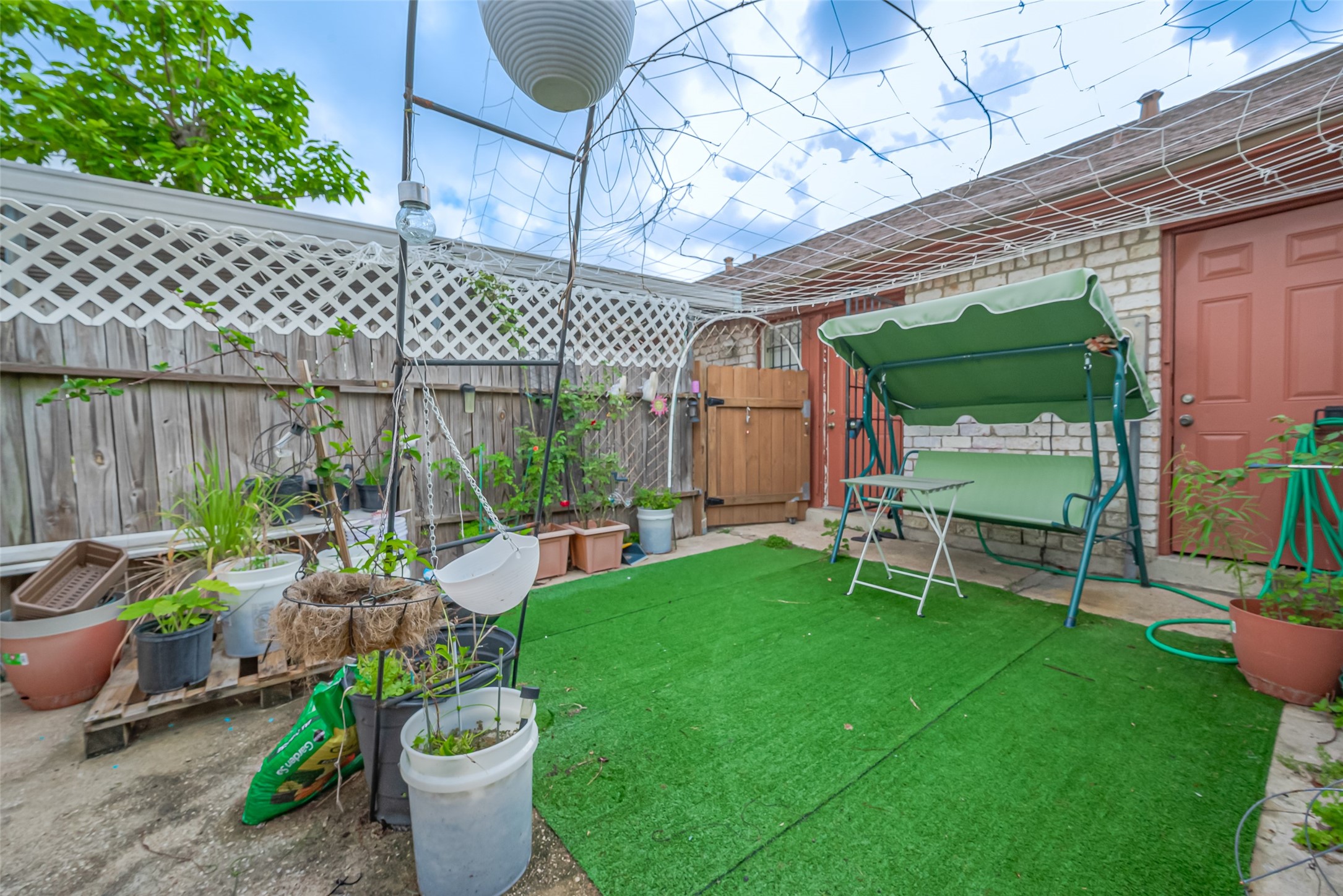 12223 Sharpview Drive Houston, TX 77072 - Photo 40 of 41 a view of a patio with table and chairs potted plants and wooden fence