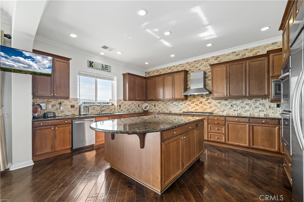 16423 Village Meadow Drive Riverside, CA 92503 - Photo 16 of 61 a kitchen with stainless steel appliances granite countertop wooden cabinets and a stove top oven